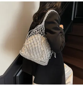 Primer plano de un bolso de malla metálica plateada con forro interior de crema