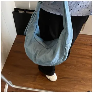 Détail du sac hobo en jean bleu clair avec forme de croissant et large bandoulière