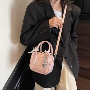 Pink bowling handbag for women with heart pendant and bow charm, crossbody style