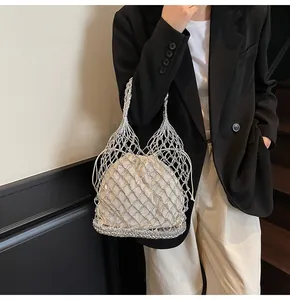 Detalle del bolso tejido plateado con forro interior de cordón en color crema