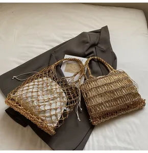Detalle de bolsos de playa tejidos dorados con forros de lona blanca para el verano