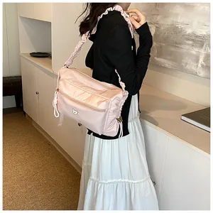 Détail du sac bandoulière rose en nylon avec sangle plissée et motif d'ours mignon