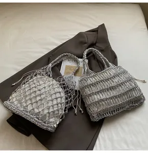 Detalle de bolsos de mano tejidos plateados con hilo metálico y forro de cordón