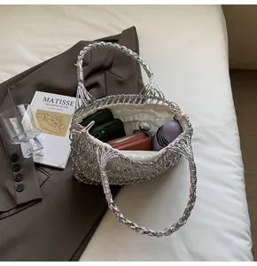 Vista detallada del bolso tejido plateado que muestra la capacidad con bolsa interior