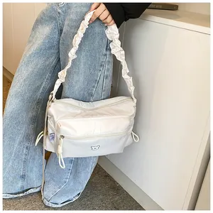 Détails du sac à bandoulière en nylon blanc avec plis et poches latérales à cordon