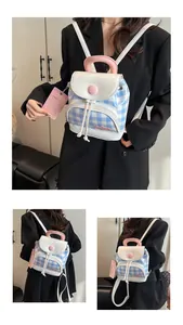Detail showing the light blue checkered fabric and white synthetic leather flap of the backpack