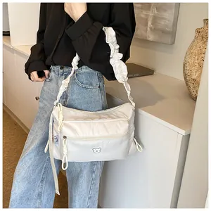 Détail de la sacoche en nylon blanc avec bandoulière à volants et broderie ours