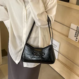 Chic black pleated faux leather underarm bag with decorative bow and slim straps