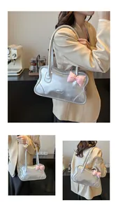 Close-up of metallic silver tote bag featuring a pink bow detail and sleek zipper finish