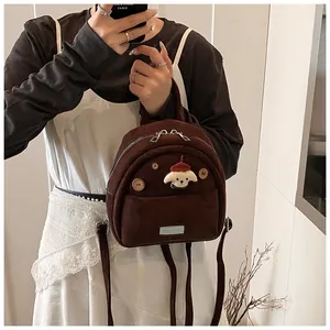 Detail of cute dark brown suede-like mini backpack with dog patch and wooden button