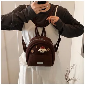 Detail of dark brown mini backpack featuring a cute white dog patch and wooden buttons