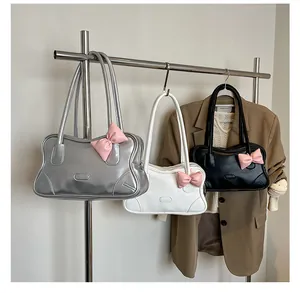 Three wave-shaped tote bags with pink bows displayed on a rack for fashion styling