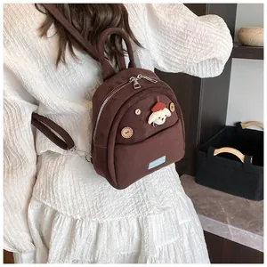 Detail of cute brown mini backpack featuring corduroy texture and decorative puppy patch