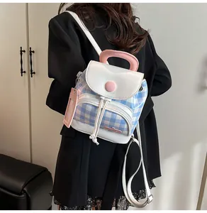 Detailed side view of a blue and white checkered mini backpack with pink charm on a model