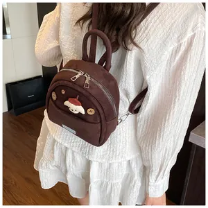 Close-up of a cute brown mini backpack with cartoon puppy embroidery and retro textures