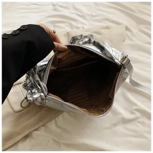 Détail du sac en nylon argenté montrant la doublure de marque et la fermeture éclair