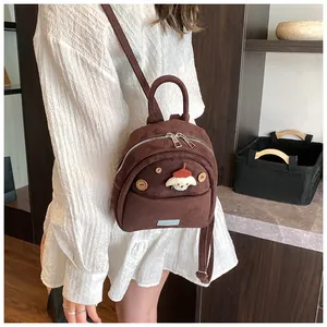 Detail of cute puppy cartoon figure on a brown mini backpack with wood button accents