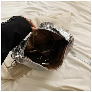 Vue détaillée de l'intérieur du sac argenté métallisé avec doublure et accessoires
