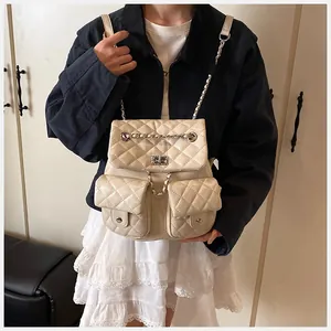 Detail of off-white quilted backpack with silver chain straps and metallic twist locks
