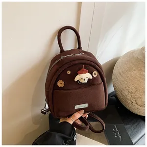 Detail of cute brown suede backpack with cartoon dog patch and wooden buttons