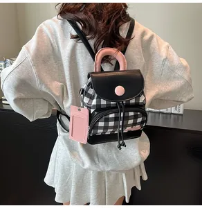 Close-up of mini checkered backpack featuring pink handle and side card holder accessory
