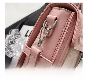 Detail shot of the pink crossbody bag showing silver metal hooks and premium stitching