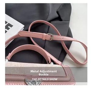 Detail of pink leather handbag showing the hardware adjustment buckle and wing ornament