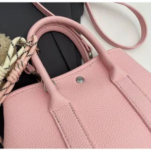 Detail of pink lychee pattern texture on bucket bag with woven charm and strap