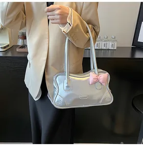 Detail of silver metallic tote bag featuring a cute pink bow and sleek PU texture