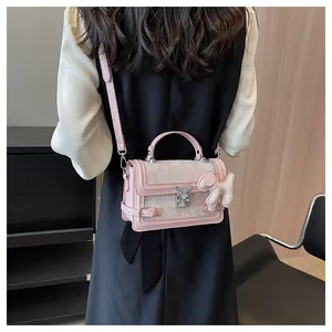 Rear view of pink floral shoulder bag with butterfly clasp and plush charm on model