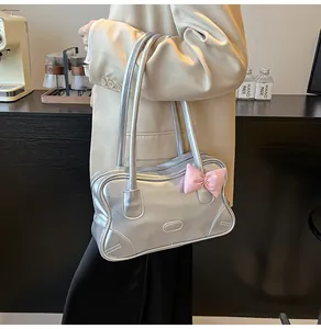 Close-up of a silver metallic tote bag featuring a decorative pink ribbon bow detail