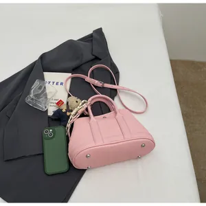 Pink lychee grain leather mini tote bag detail with teddy charm and floral scarf