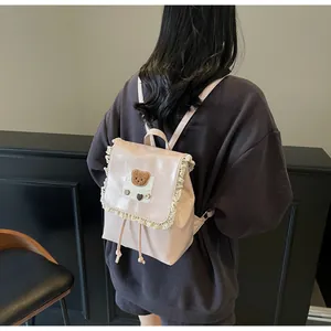 Detail eines rosa PU-Lederrucksacks mit Spitzenbesatz und Plüschbär-Dekoration