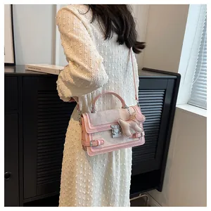 Chic pink and white crossbody bag shown on model wearing a white textured dress