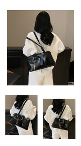 Close-up of black motorcycle shoulder bag with silver hardware and mini pouch detail