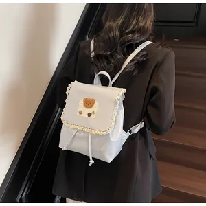Nahaufnahme hellblauer Mini-Rucksack mit süßem Bären-Aufnäher und weißen Spitzendetails