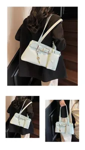 Detail of mint green shoulder bag with belt buckle straps and detachable mini pouch