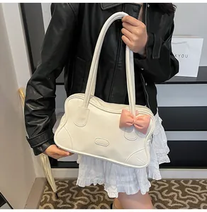 Detail of off-white PU tote bag featuring a cute pink bow and long shoulder straps