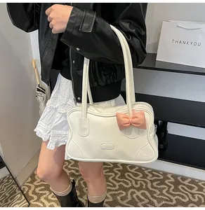 Detail of cream white PU tote bag with pink bow accent and dual shoulder straps