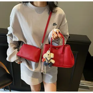 Detail of red lychee grain leather bucket bag set with a cute plush dog pendant charm
