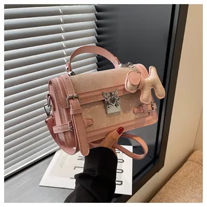 Detail of pink jacquard handbag featuring silver cross lock and fuzzy horse charm