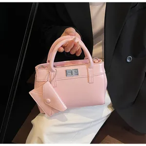Detail of light pink faux leather handbag with silver twist lock and mini envelope charm