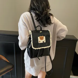Glänzender schwarzer Rucksack mit weißer Spitze und Bärenmotiv für stylische Damen