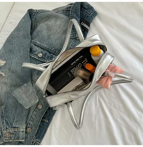 Silver tote bag interior showing large capacity for books and cosmetics with bow detail