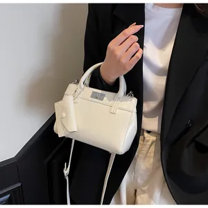 Detail of off-white PU leather handbag with silver twist lock and mini envelope pouch