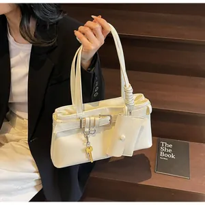 Chic cream leather shoulder bag with side strap details and small pouch on wooden steps