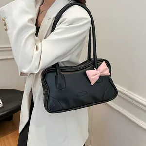 Large black tote bag with pink bow accent and sleek shoulder straps for women