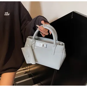 Detail of light blue patent leather handbag with silver twist lock and mini pouch