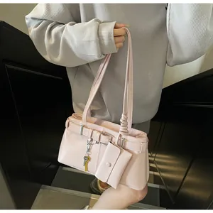 Glossy pink patent leather shoulder bag with decorative buckle and mini pouch charm