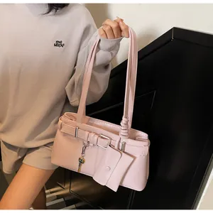 Detail of pink moto-style shoulder bag with mini pouch and key charm accessory